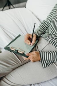 A stock photo of a woman writing on a notepad.