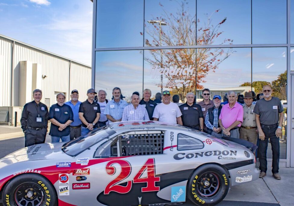 The attendees of the Dash Series Reunion who were drivers, posing for a photo in front of Hendrick Motorsports.