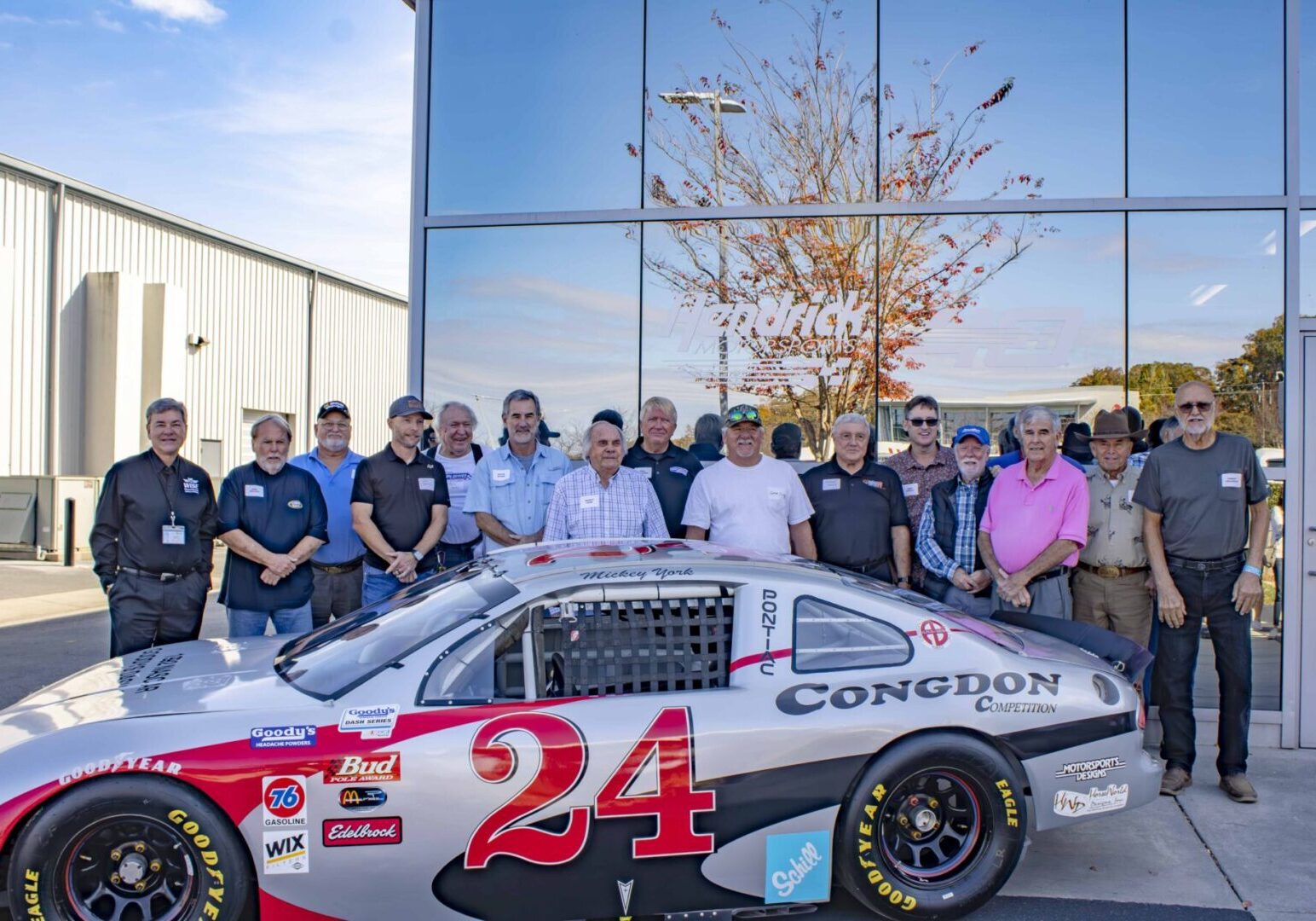 The attendees of the Dash Series Reunion who were drivers, posing for a photo in front of Hendrick Motorsports.