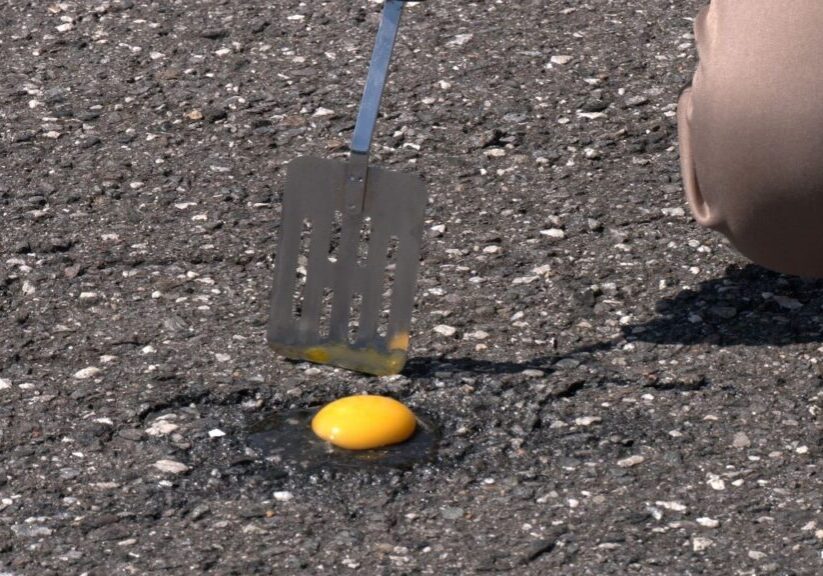 A spatula and an orange on the ground.