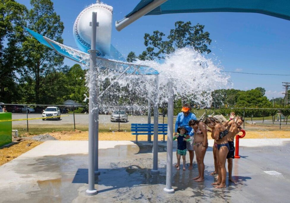 A group of people standing under a water fountain.