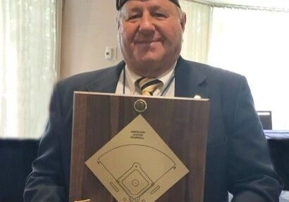 A man in a uniform holding a plaque.