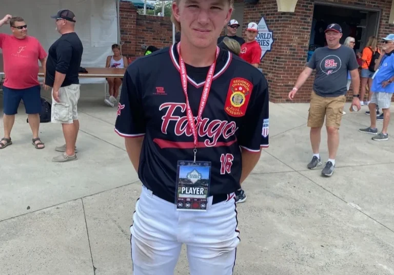 A baseball player in a black shirt and white pants.