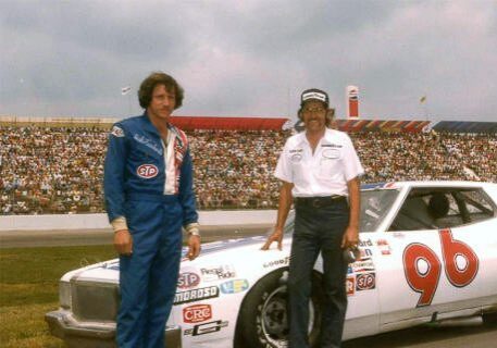 Will Cronkrite standing beside the number 96 car with its driver for NASCAR.